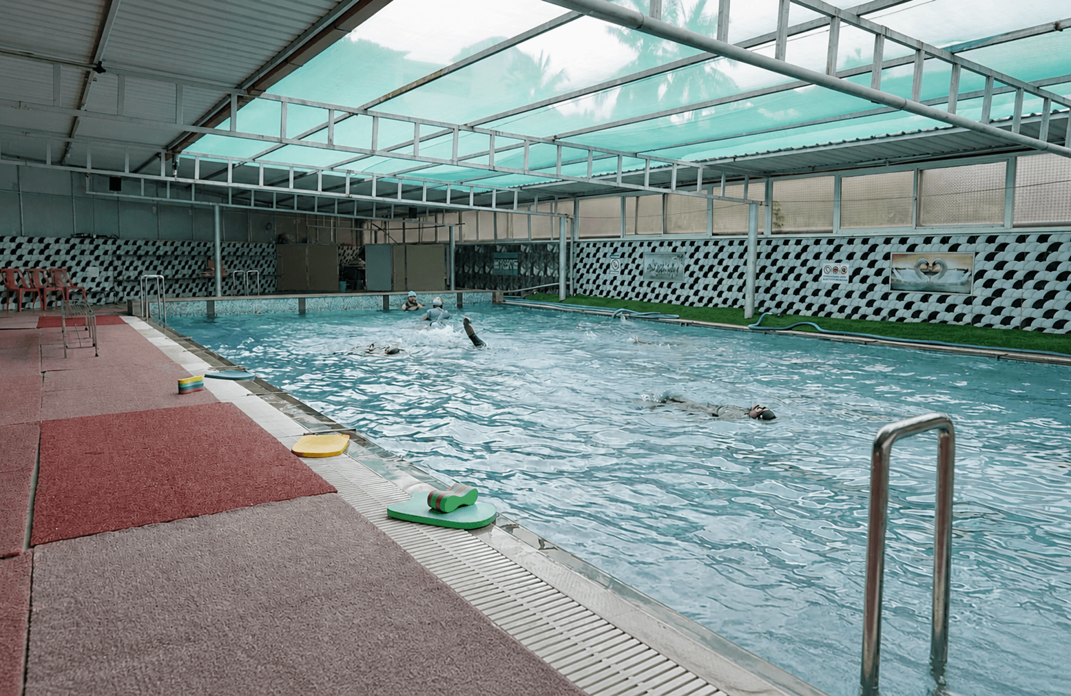 Covered KVG campus swimming pool with students during a swim session