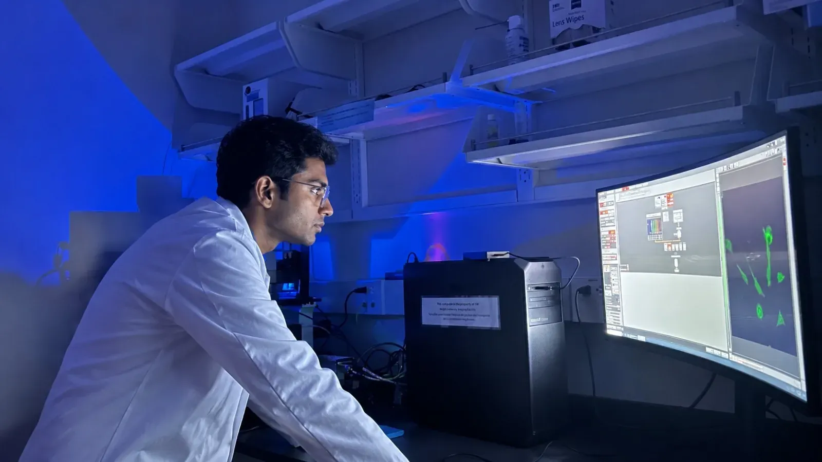 Researcher examining fluorescence microscopy results in a laboratory