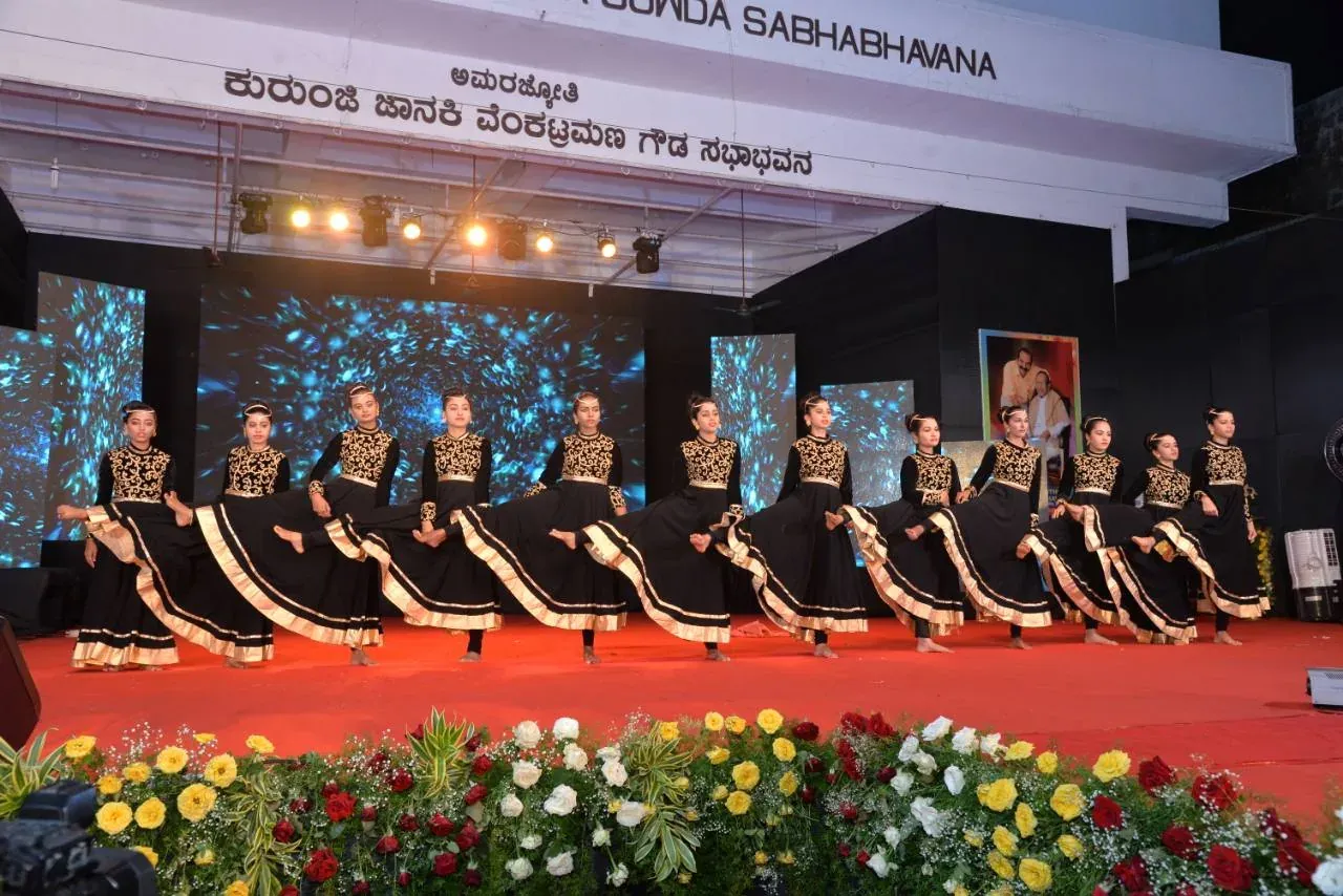 Students performing a group dance in black and gold costumes
