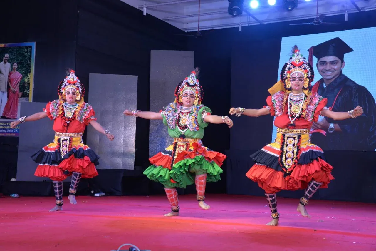 Three students performing a traditional dance on stage